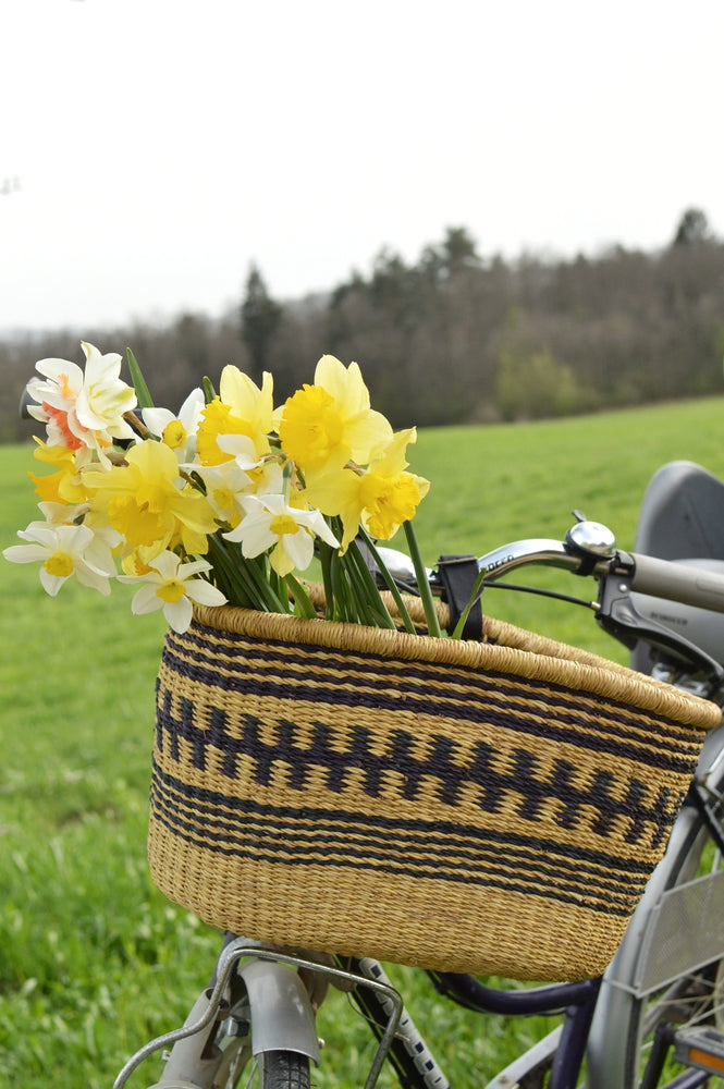 daffodils bouquet in a straw bike basket