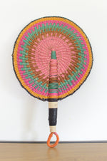 colorful round bolga fan with leather handle on a white background