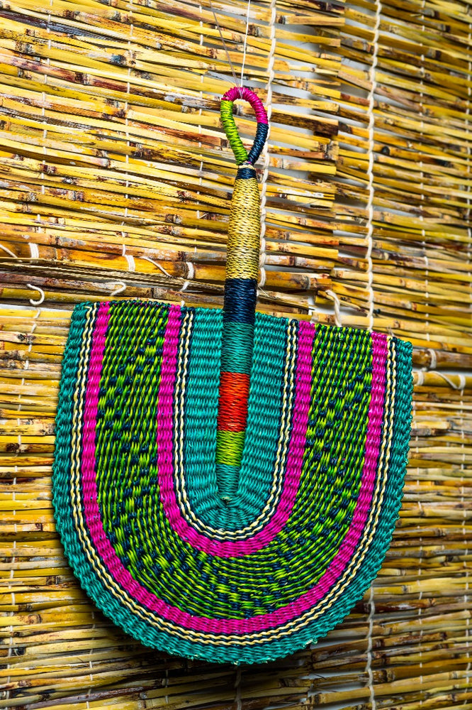 colorful bolga fan hanged on a bamboo blind